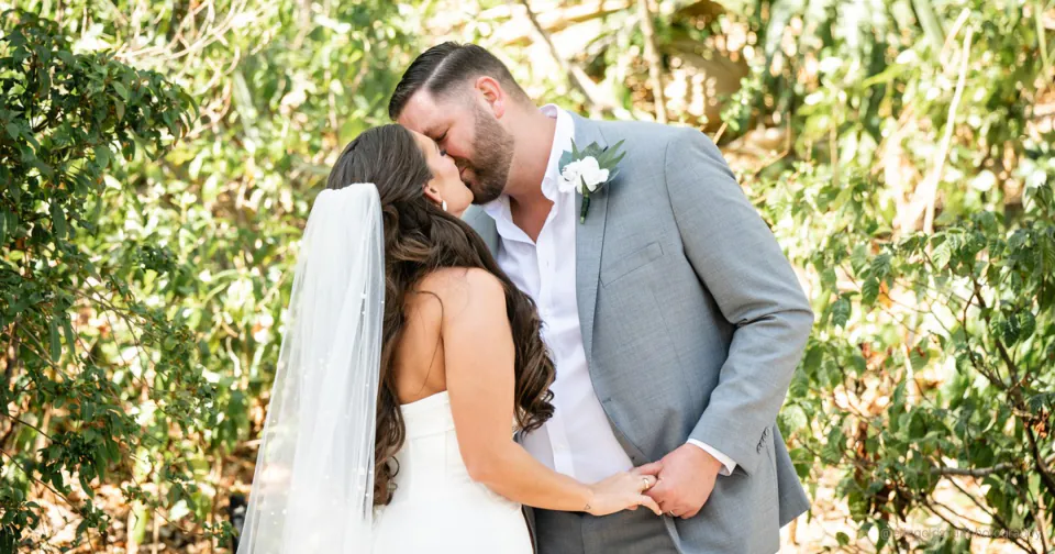 Couple sharing an unscripted laugh during their wedding day portraits at golden hour