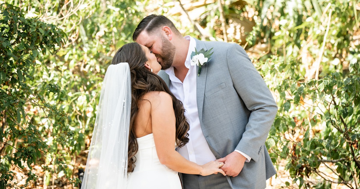 Couple sharing an unscripted laugh during their wedding day portraits at golden hour