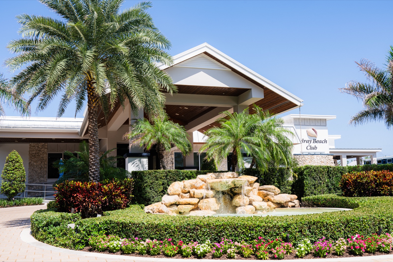 Entrance to the Delray Beach Club in Delray Beach, Florida, with fountain, palm trees, and manicured grounds