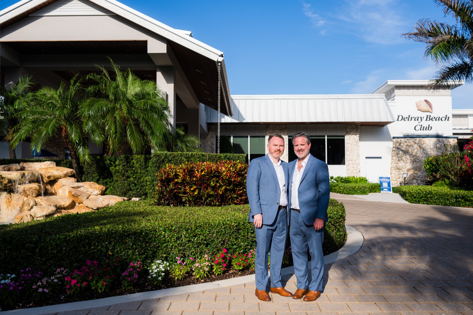 John and Reed standing in front of the Delray Beach Club entrance sign on their wedding day