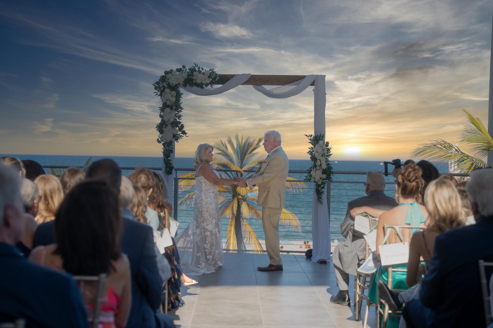 Ceremony at The Oceanic, couple at the altar with ocean behind them, golden hour light